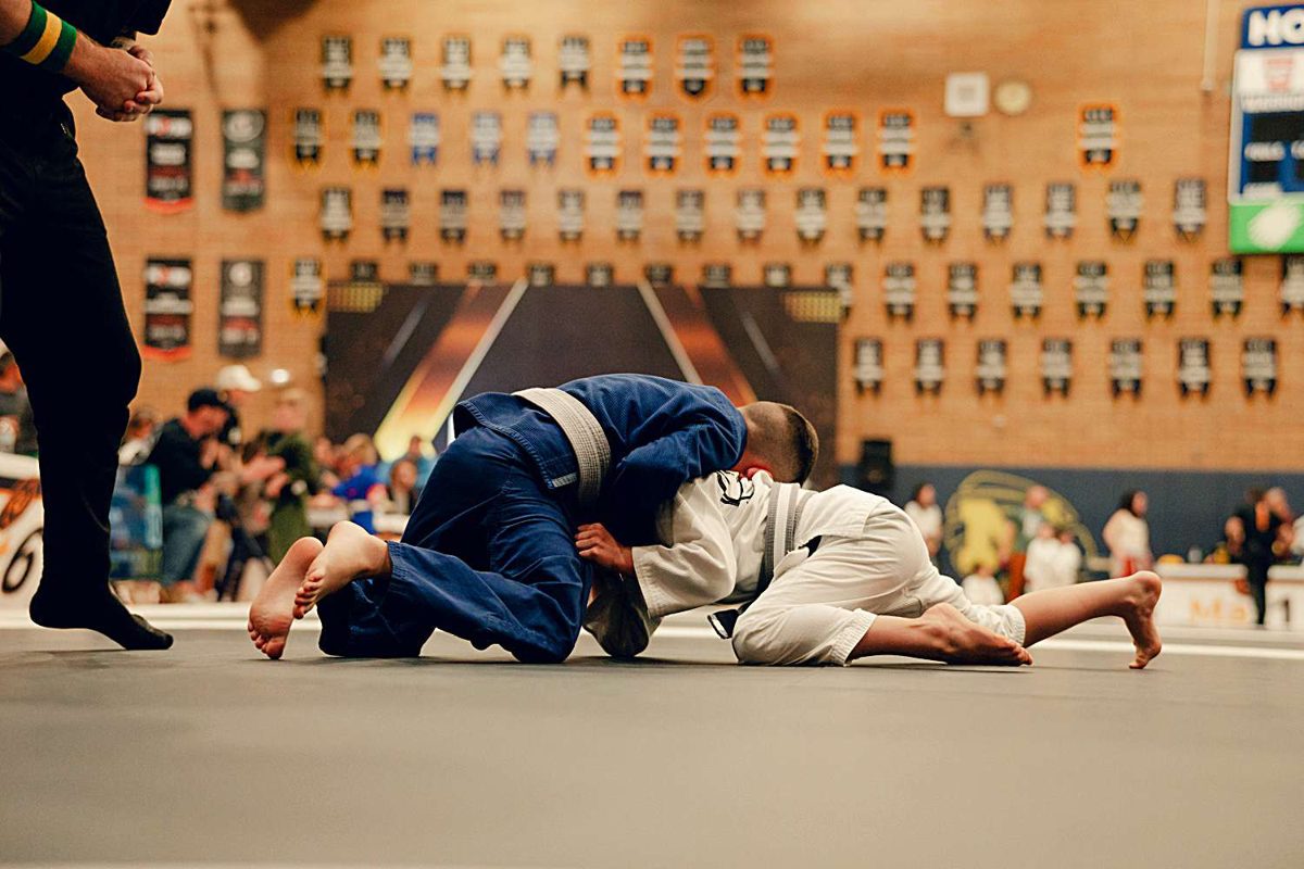 Blue and white gi athletes scrambling on the mat