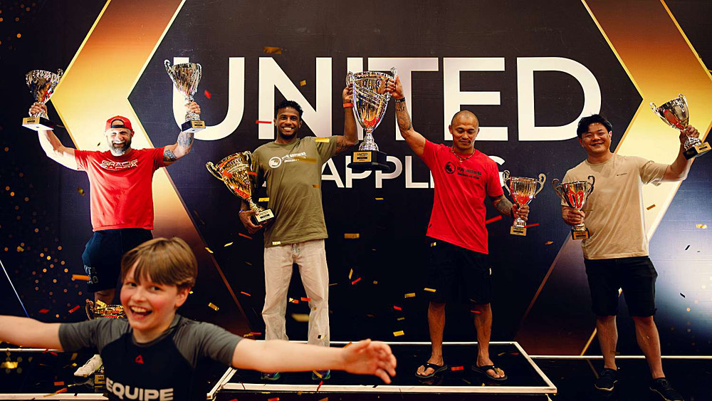 Champions celebrating on the podium with trophies and confetti